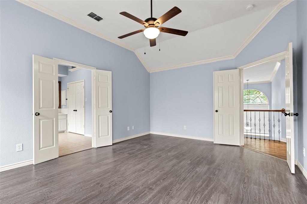 2604 Ridgewood Drive Plano, TX 75074 - Photo 19 of 35 Spacious room featuring vaulted ceilings with crown molding, wood-finish flooring, and a ceiling fan with integrated lighting