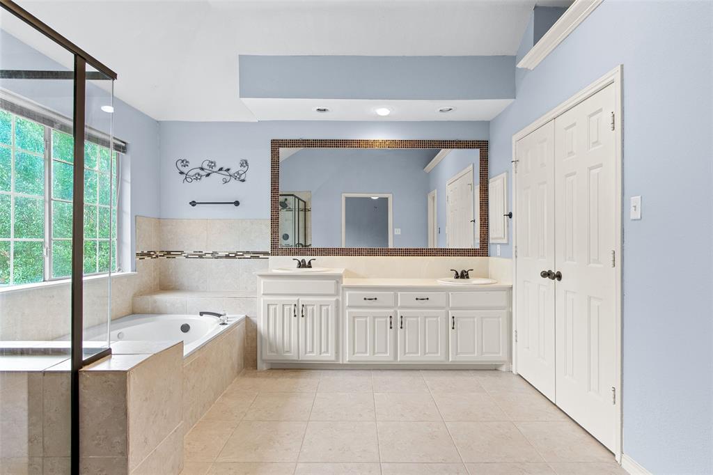 2604 Ridgewood Drive Plano, TX 75074 - Photo 21 of 35 Spacious bathroom with dual vanities, a large soaking tub, and a separate glass-enclosed shower