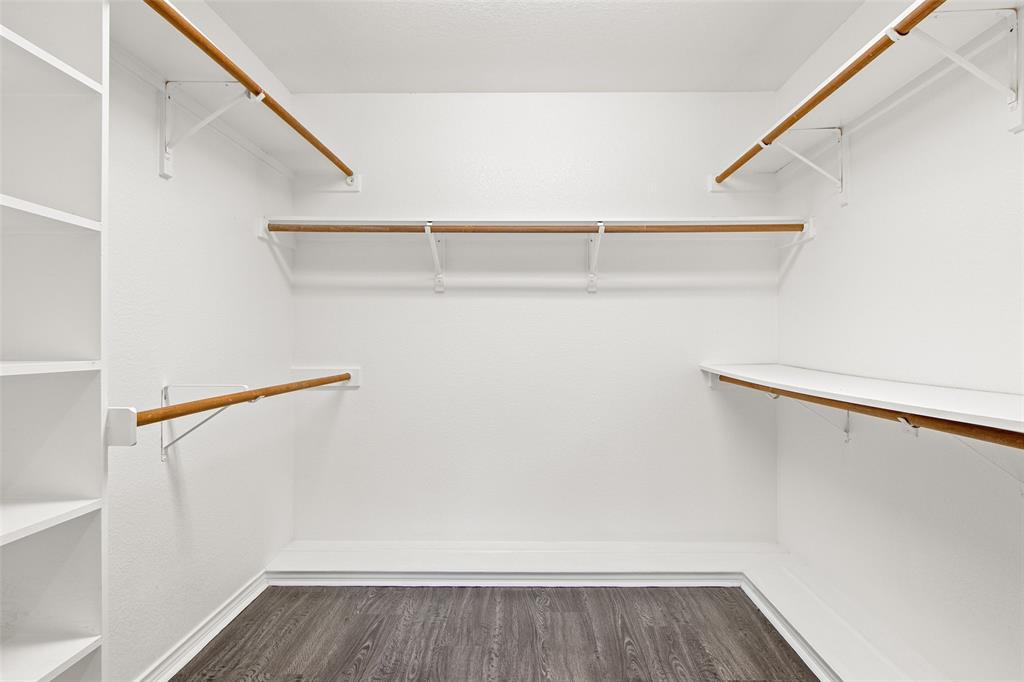 2604 Ridgewood Drive Plano, TX 75074 - Photo 23 of 35 Walk-in closet featuring built-in shelving, multiple hanging rods, and wood-finish flooring