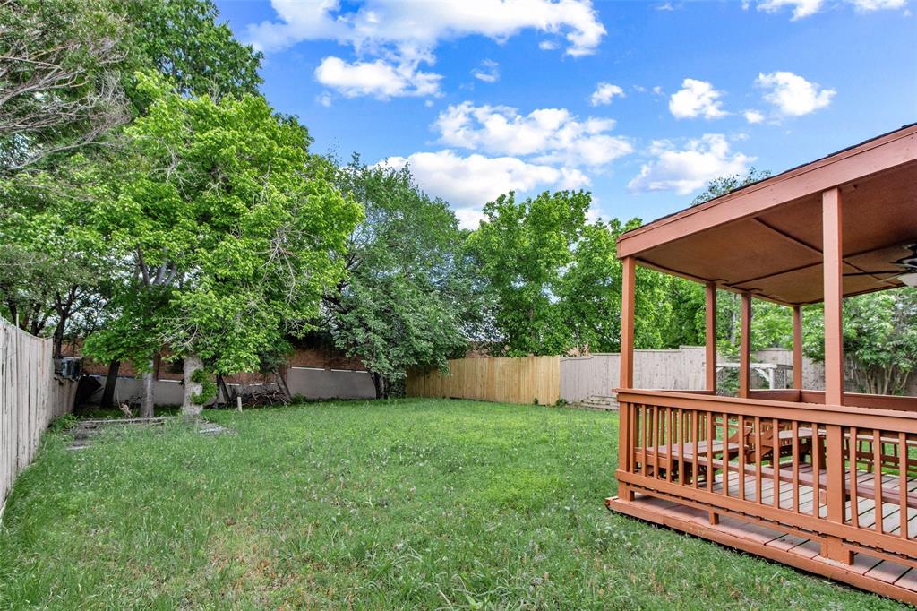 2604 Ridgewood Drive Plano, TX 75074 - Photo 33 of 35 Expansive backyard featuring a covered patio with wood railing, wood decking, and mature trees
