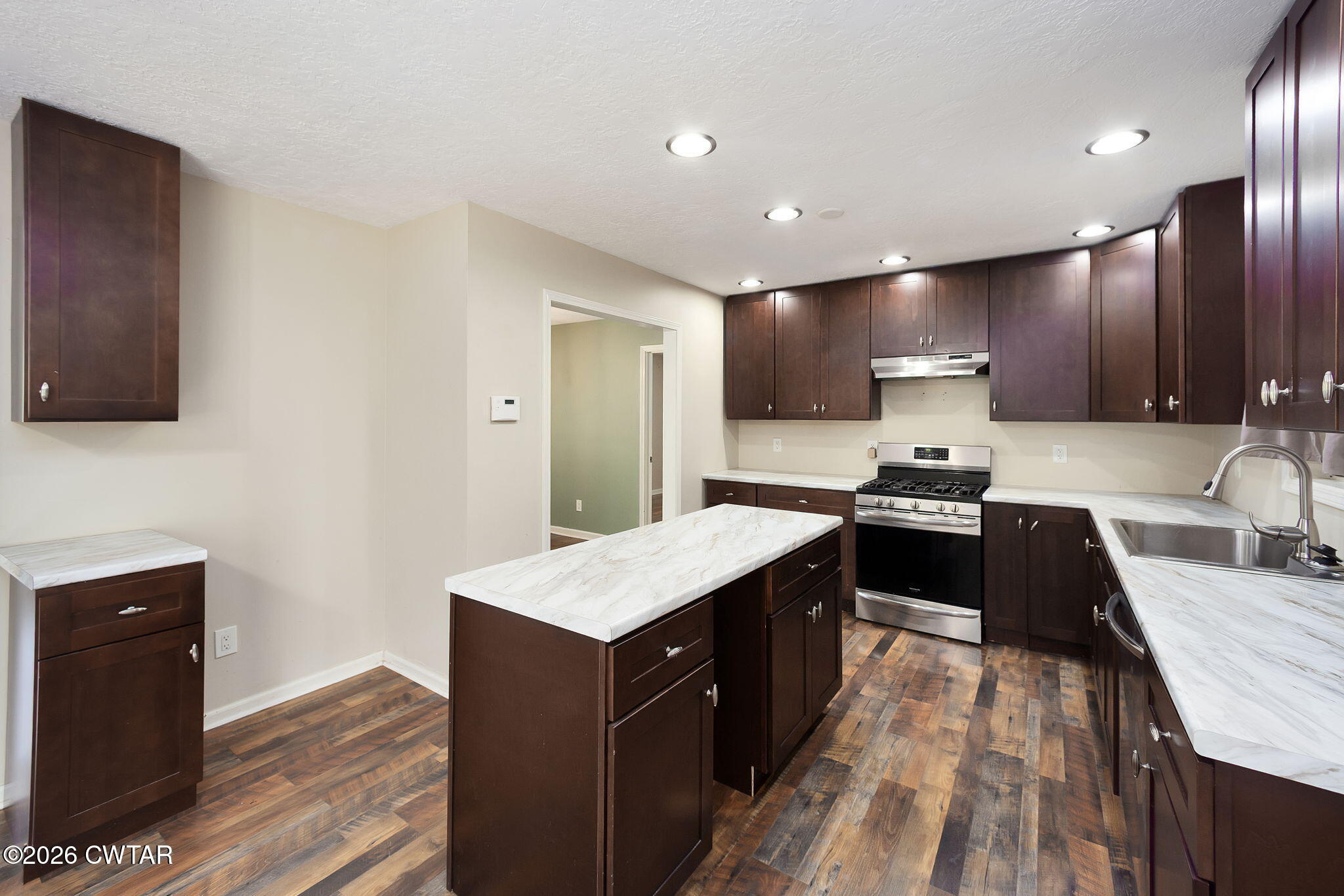 306 Jim Jackson Road Humboldt, TN 38343 - Photo 13 of 29 a large kitchen with stainless steel appliances granite countertop a stove a sink dishwasher and a refrigerator with wooden floor