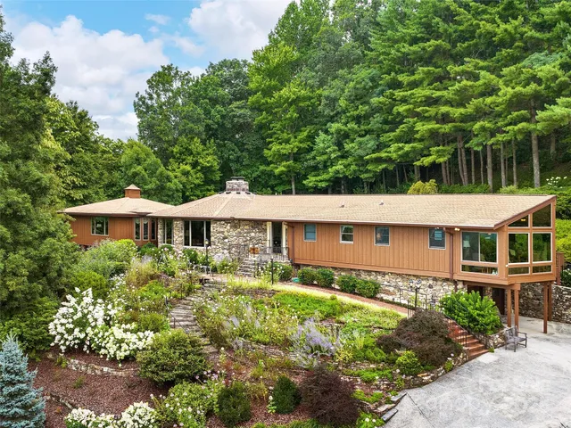 a view of a house with backyard and sitting area