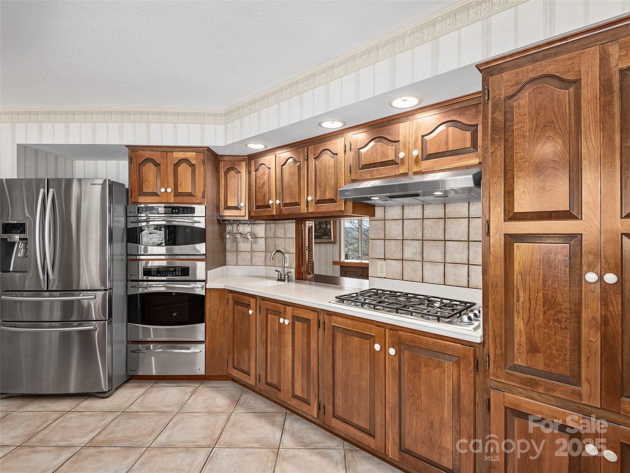 1300 Randy Drive Hendersonville, NC 28791 - Photo 12 of 48 a kitchen with stainless steel appliances granite countertop a stove a refrigerator and a wooden cabinets