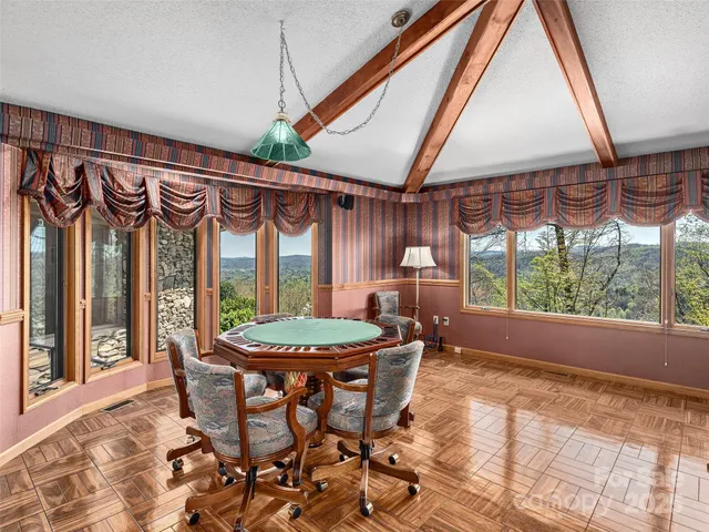 a dining room with furniture and a floor to ceiling window