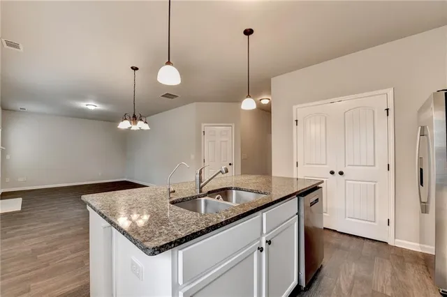 a kitchen with a sink chandelier and wooden floor