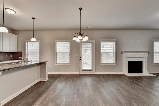 a view of a room with wooden floor and kitchen view