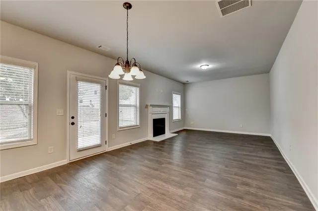a view of a livingroom with a chandelier fireplace and wooden floor