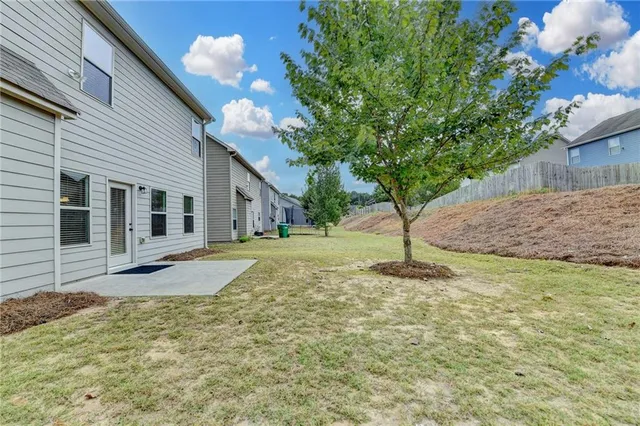 a backyard of a house with table and chairs