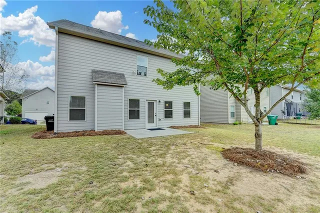 a white house that has a tree in front of it