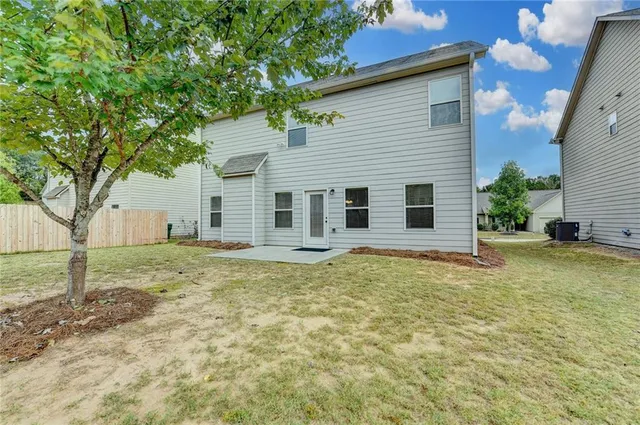a backyard of a house with table and chairs