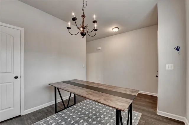 a view of a hallway with wooden floor and chandelier