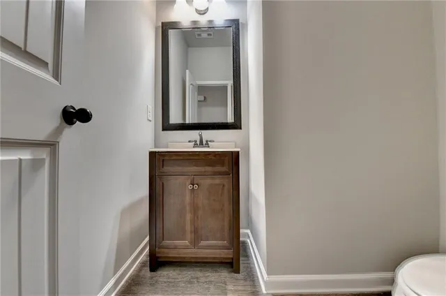 a bathroom with a toilet sink vanity and mirror