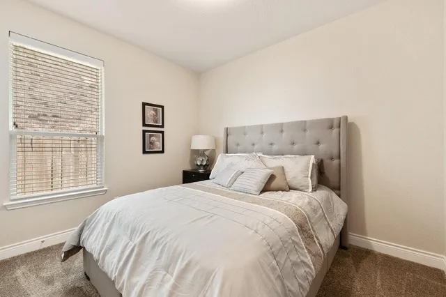 a large bed sitting in a bedroom next to a window