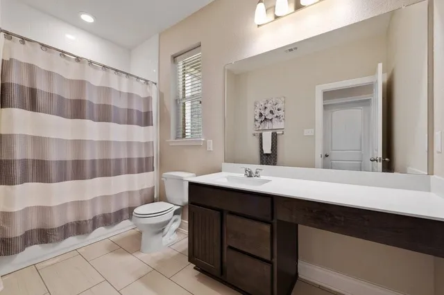 a bathroom with a double sink toilet a mirror and shower