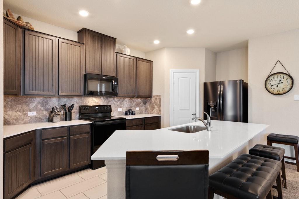 2471 Sunrise Road, Unit 16 Round Rock, TX 78664 - Photo 5 of 28 a kitchen with stainless steel appliances granite countertop a sink stove refrigerator and cabinets