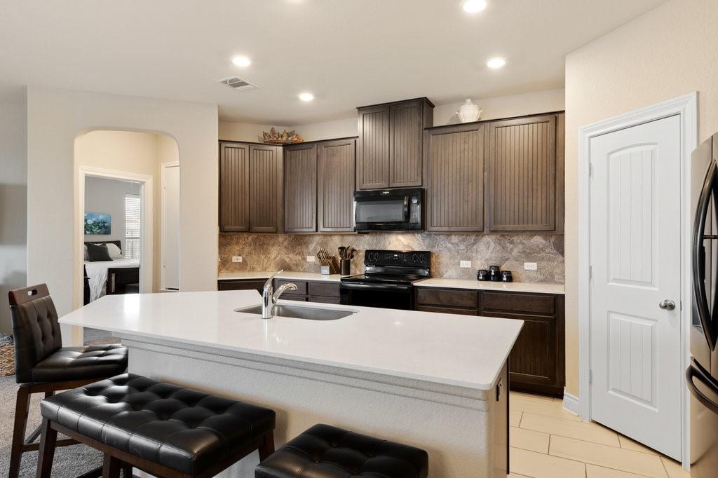 2471 Sunrise Road, Unit 16 Round Rock, TX 78664 - Photo 6 of 28 a kitchen with kitchen island a sink stove and refrigerator