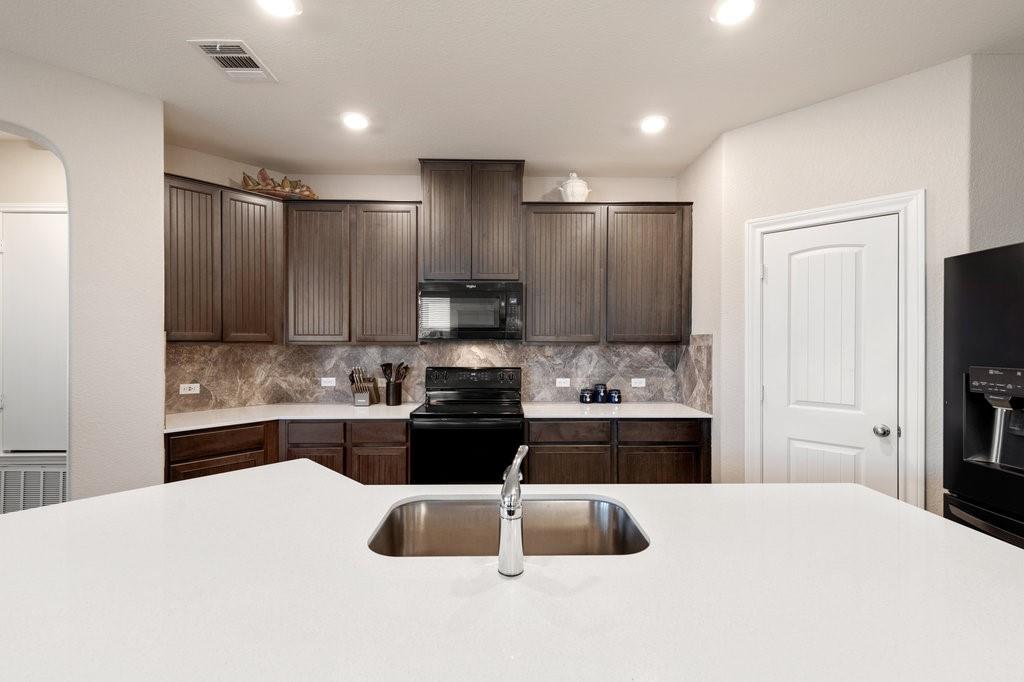 2471 Sunrise Road, Unit 16 Round Rock, TX 78664 - Photo 7 of 28 a kitchen with kitchen island granite countertop a stove sink and refrigerator