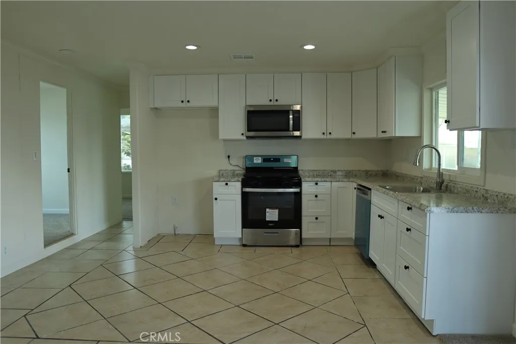 1855 East Riverside Drive, Unit 48 Ontario, CA 91761 - Photo 5 of 20 a kitchen with granite countertop white cabinets and stainless steel appliances