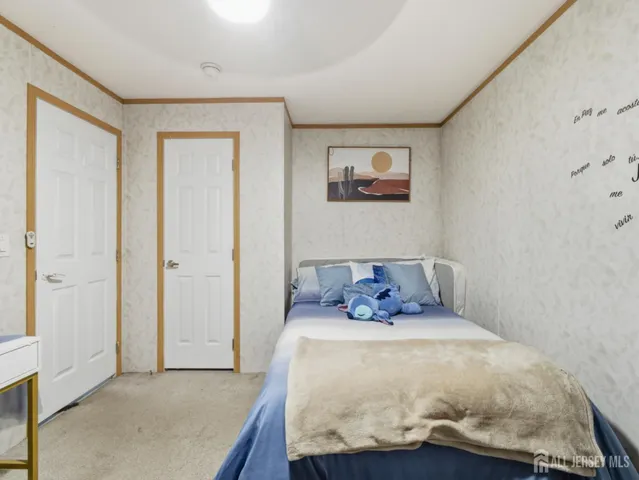 a bed sitting in a bedroom next to a bathroom