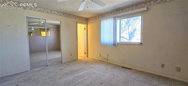 6313 Chippewa Road Colorado Springs, CO 80915 - Photo 35 of 36 Unfurnished bedroom with ceiling fan, light colored carpet, a closet, and a textured ceiling