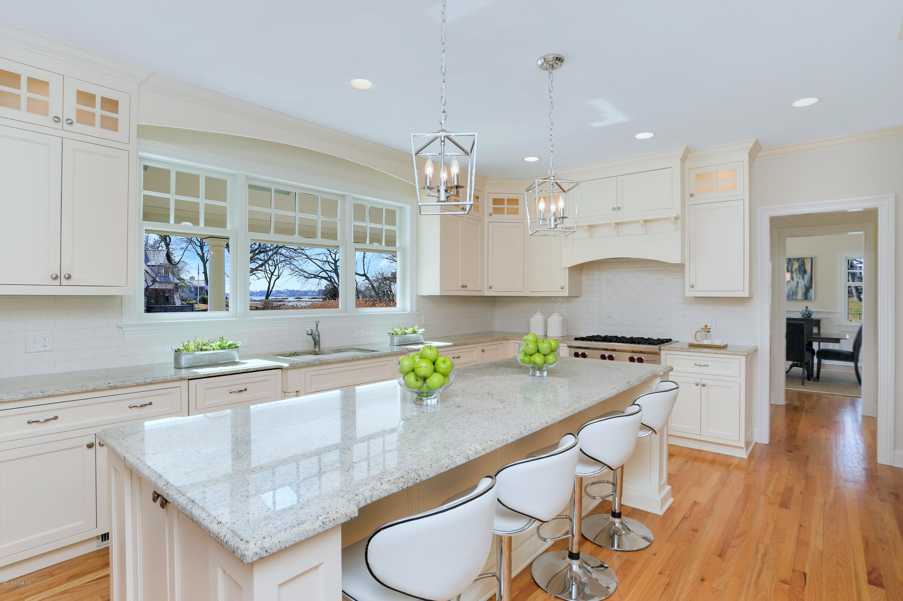 4 Highgate Road Riverside, CT 06878 - Photo 4 of 33 a large kitchen with granite countertop a table chairs in it and wooden floors
