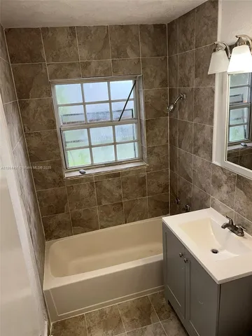 a bathroom with a bath tub a sink and a window