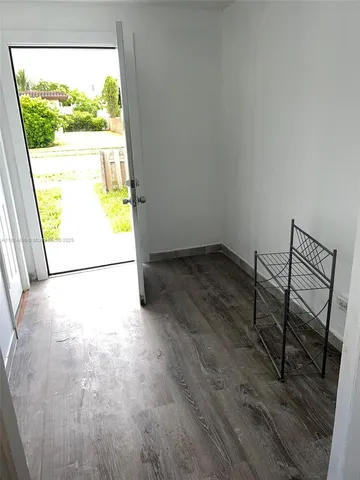 a view of a room with wooden floor and a window