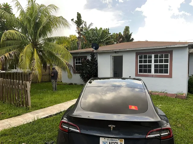 a car parked in front of a house with a yard