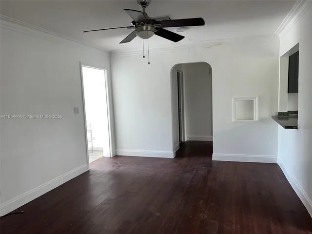 a view of a livingroom with wooden floor and a ceiling fan