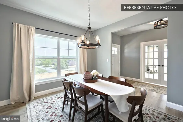 a dining room with furniture a chandelier and wooden floor