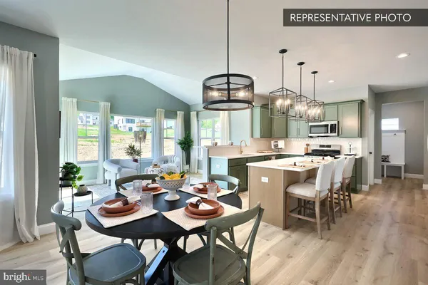 a dining room with stainless steel appliances kitchen island a table and chairs in it