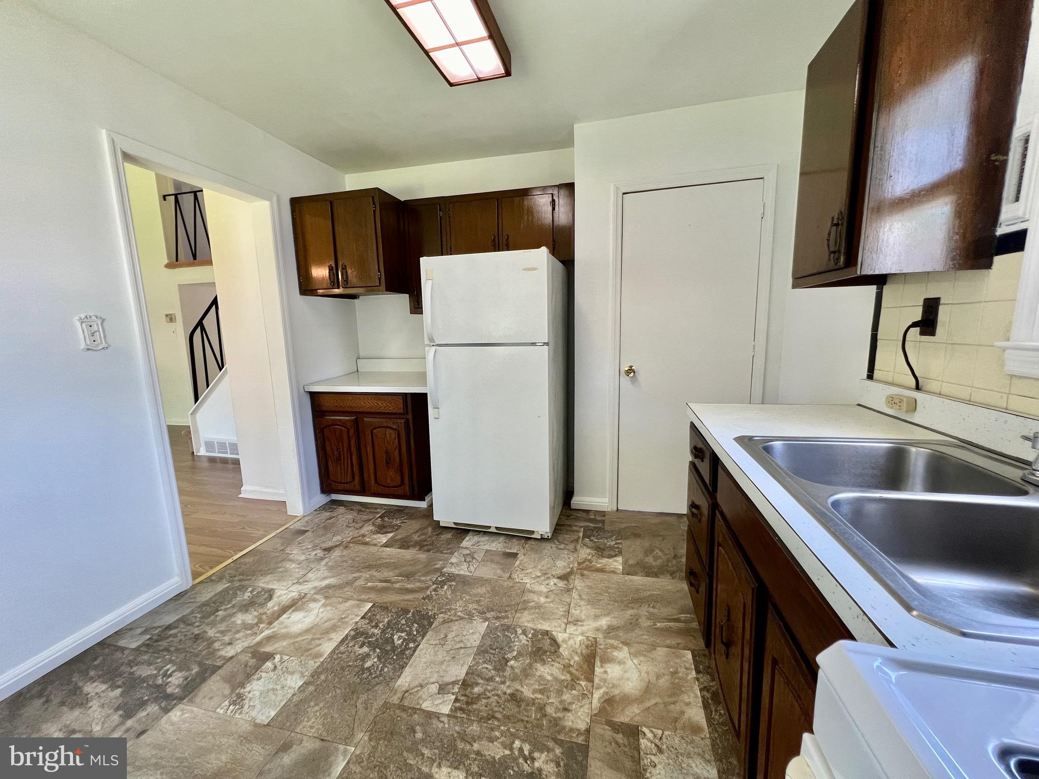 158 Brookside Boulevard Newark, DE 19713 - Photo 7 of 27 a kitchen with stainless steel appliances granite countertop a refrigerator a stove and a sink with wooden floor