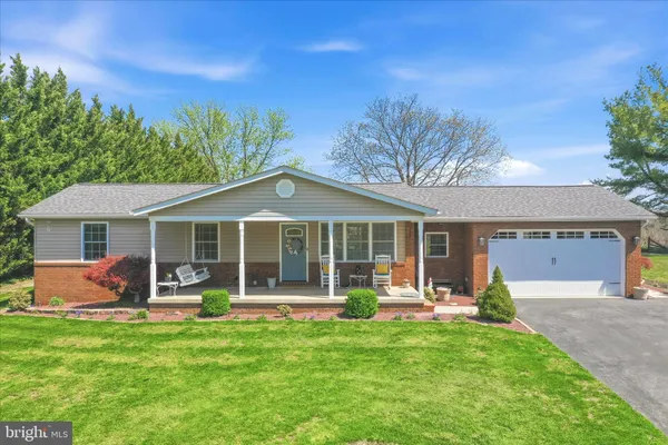 a front view of a house with a garden and trees