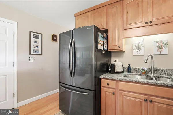 a bathroom with a granite countertop sink toilet a mirror and a window