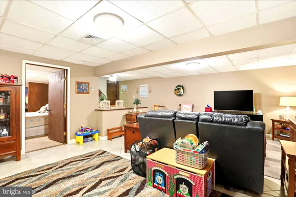 a kitchen with stainless steel appliances kitchen island granite countertop a dining table chairs and a refrigerator
