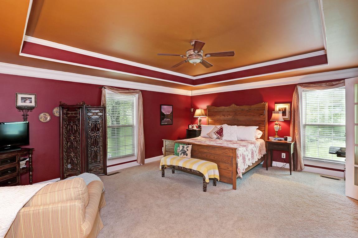1690 Alf Harris Road Prospect, TN 38477 - Photo 18 of 30 a spacious bedroom with a bed and a chandelier