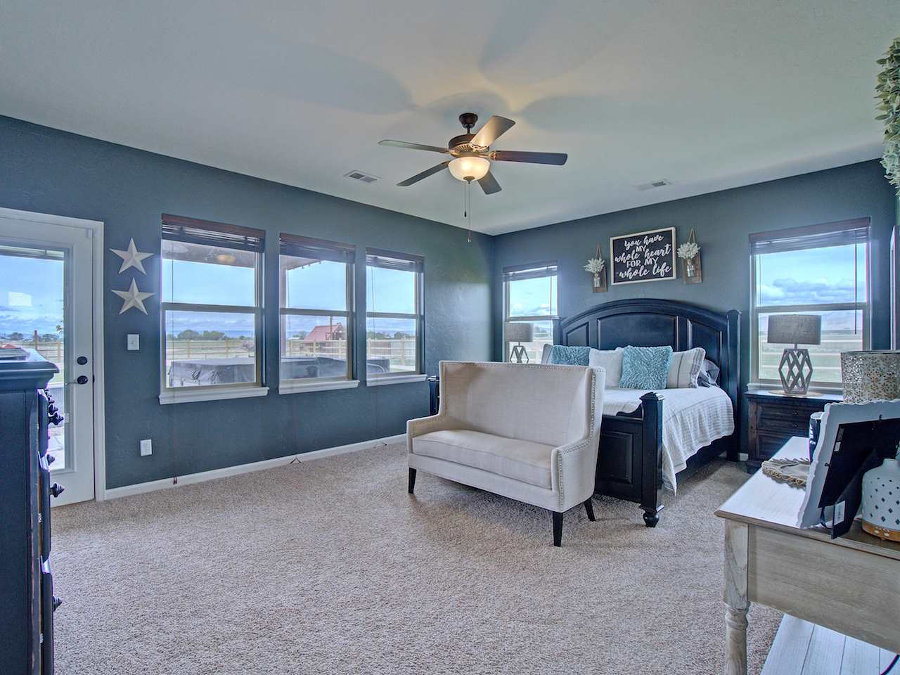 1171 Toscano Road Fruita, CO 81521 - Photo 13 of 27 a spacious bedroom with a bed couch and a large window