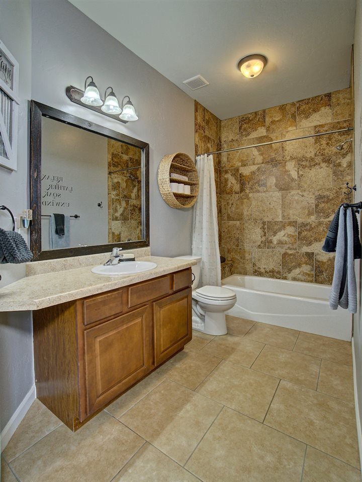 1171 Toscano Road Fruita, CO 81521 - Photo 20 of 27 a bathroom with a double vanity sink a toilet a mirror and shower