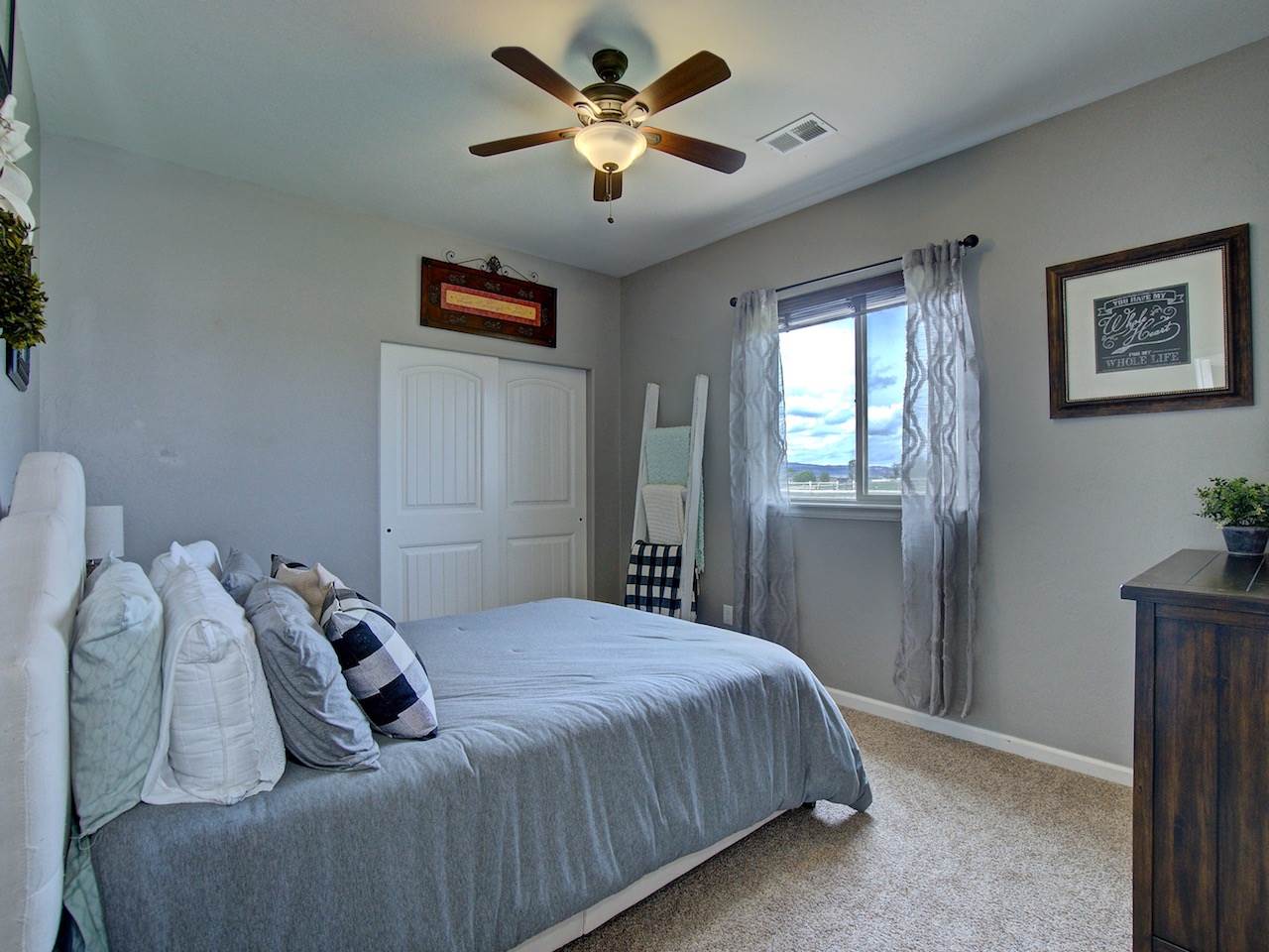 1171 Toscano Road Fruita, CO 81521 - Photo 21 of 27 a bedroom with bed and a chandelier