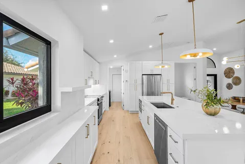 a large kitchen with lots of counter space and wooden floor