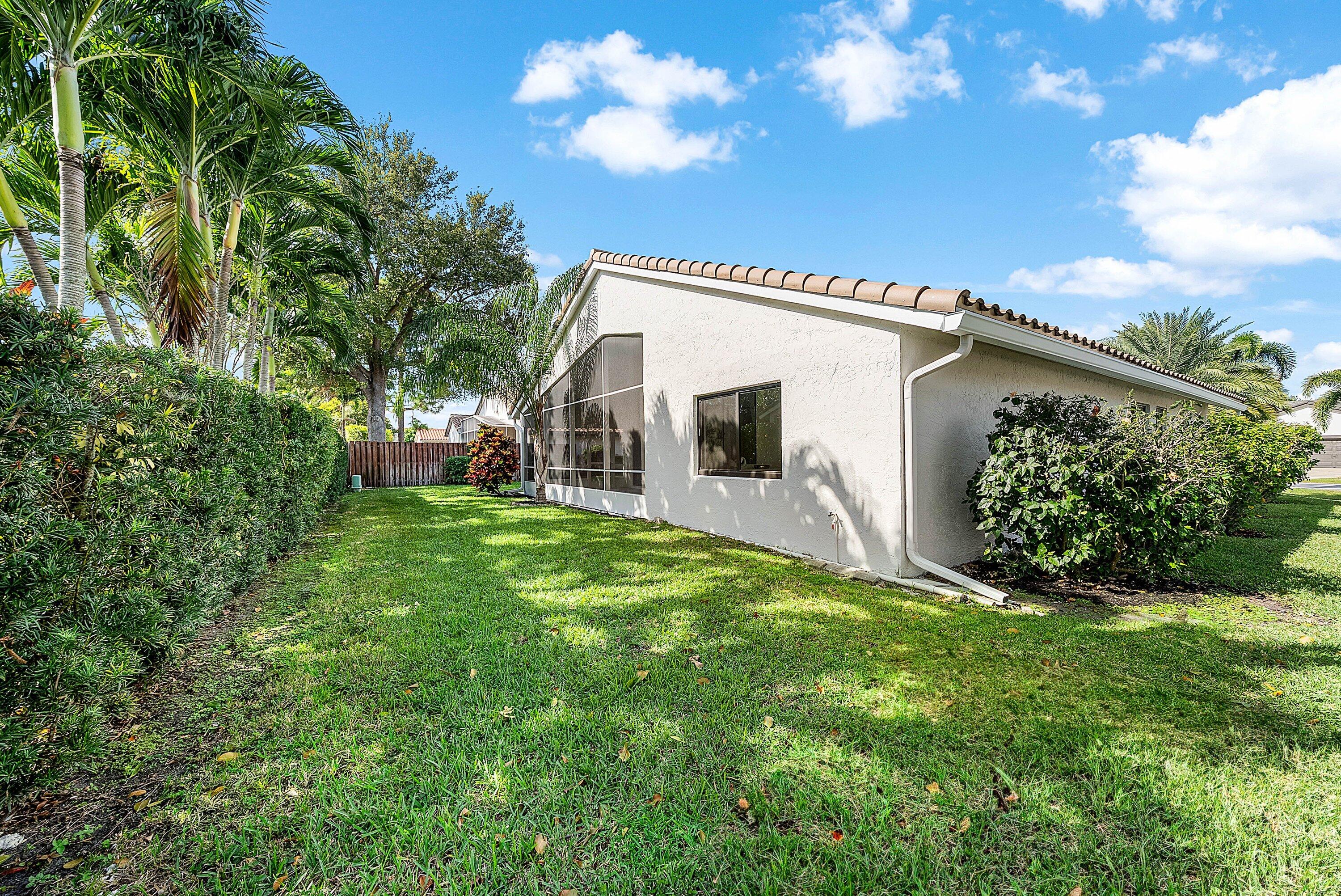 5723 Aspen Ridge Circle Delray Beach, FL 33484 - Photo 32 of 47 a backyard of a house with table and chairs plants and large tree