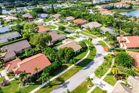 an aerial view of residential houses with outdoor space and trees all around