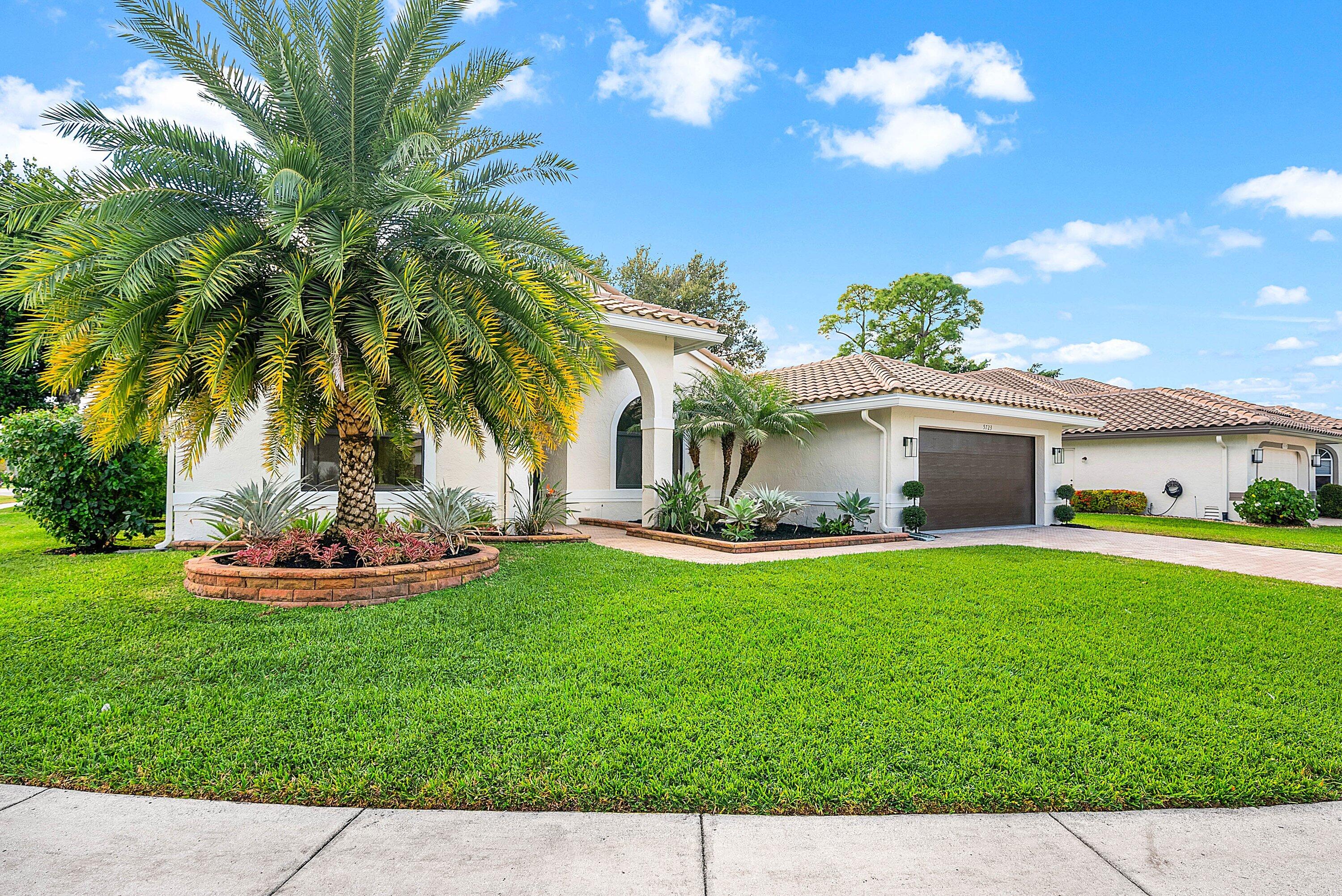 5723 Aspen Ridge Circle Delray Beach, FL 33484 - Photo 4 of 47 a front view of house with yard and outdoor seating