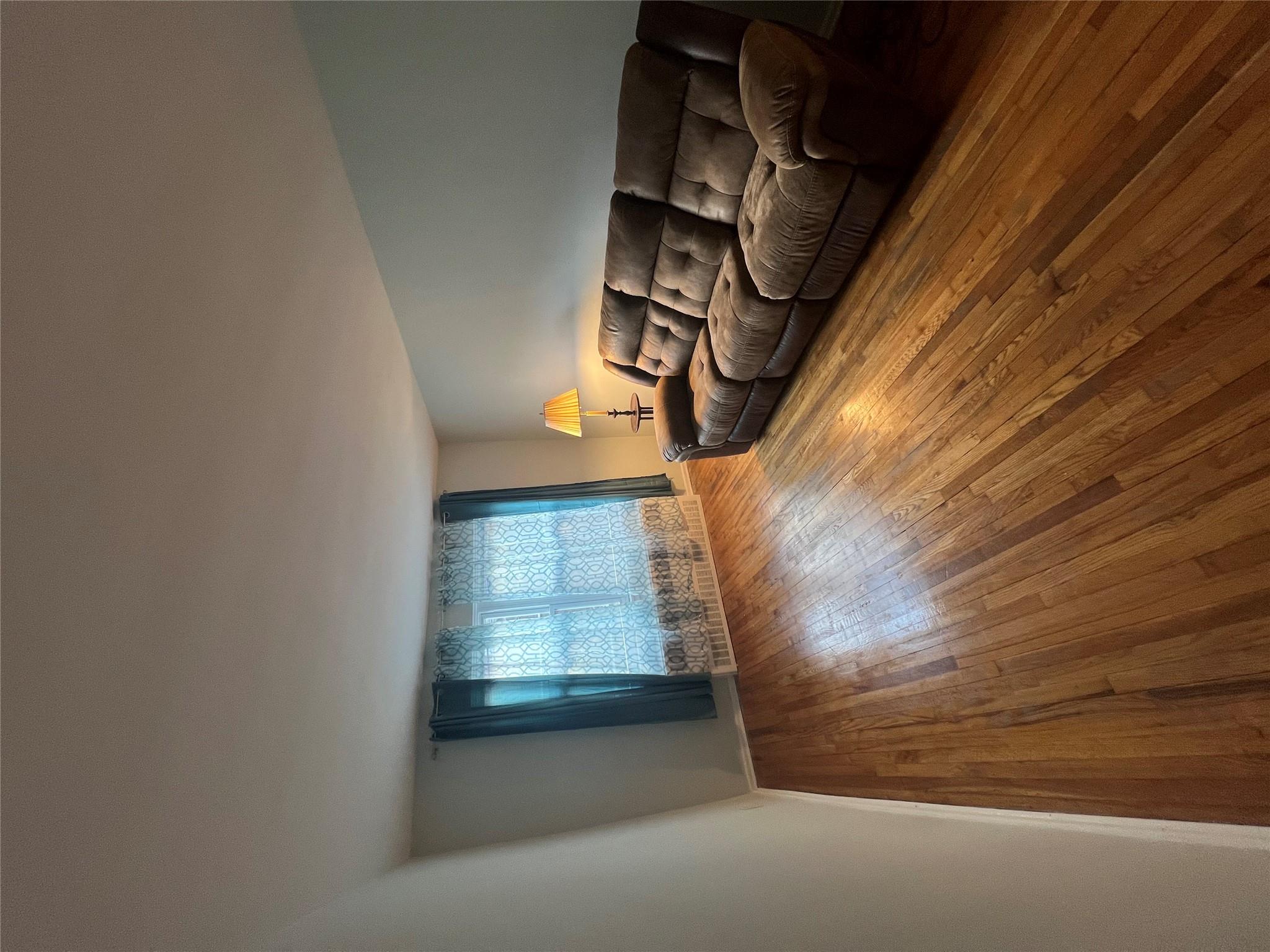 41-20 210th Street, Unit 1 Queens, NY 11361 - Photo 5 of 17 Living room with baseboards and hardwood / wood-style floors