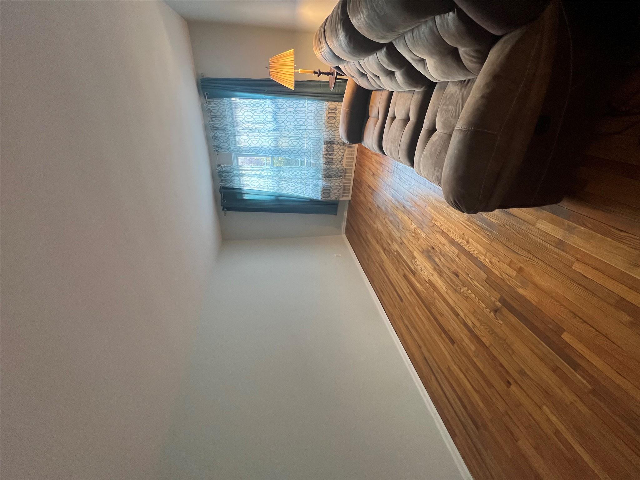 41-20 210th Street, Unit 1 Queens, NY 11361 - Photo 6 of 17 Living area featuring baseboards and wood finished floors