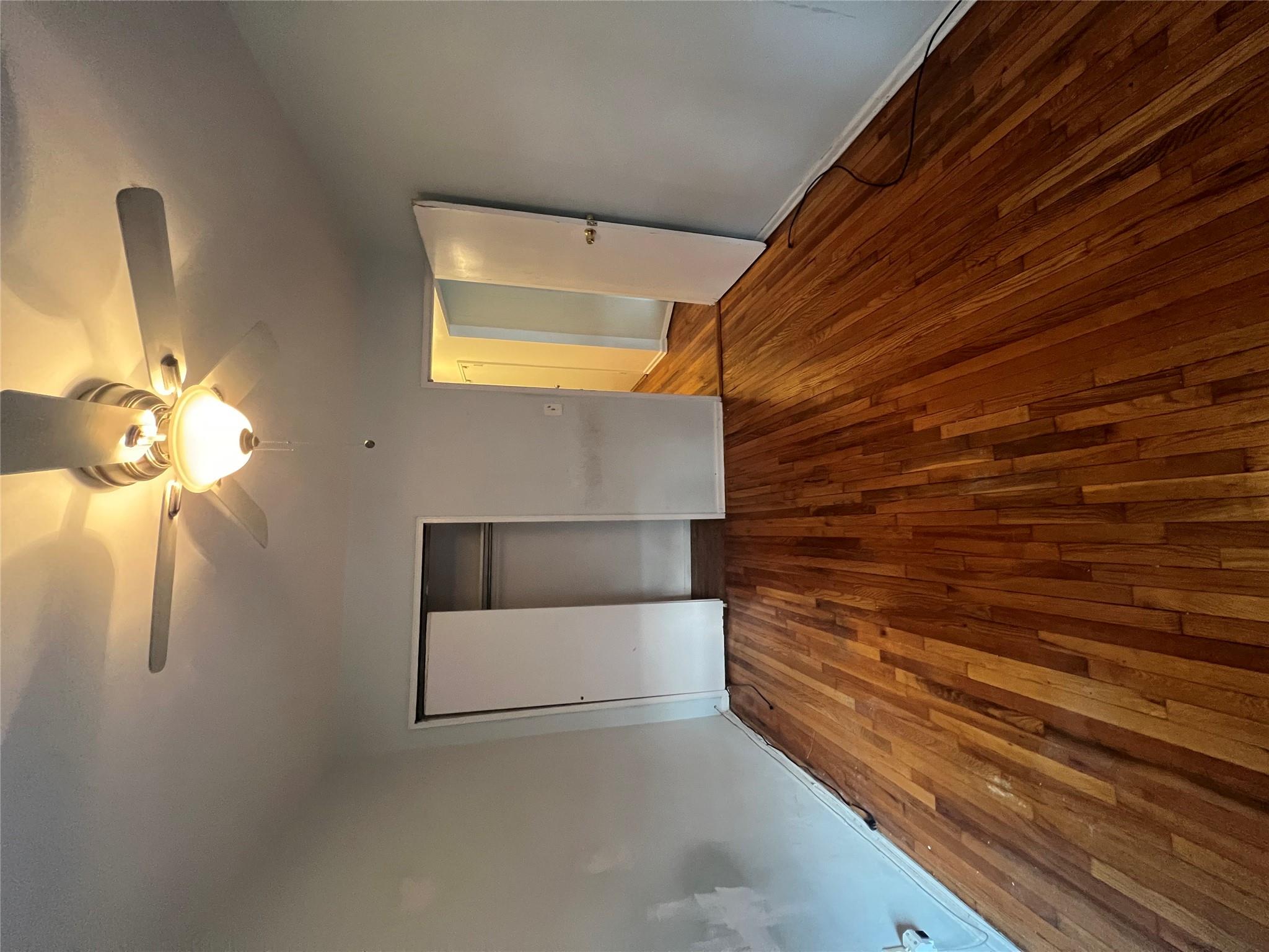 41-20 210th Street, Unit 1 Queens, NY 11361 - Photo 8 of 17 Unfurnished bedroom with wood-type flooring, a ceiling fan, baseboards, and a closet