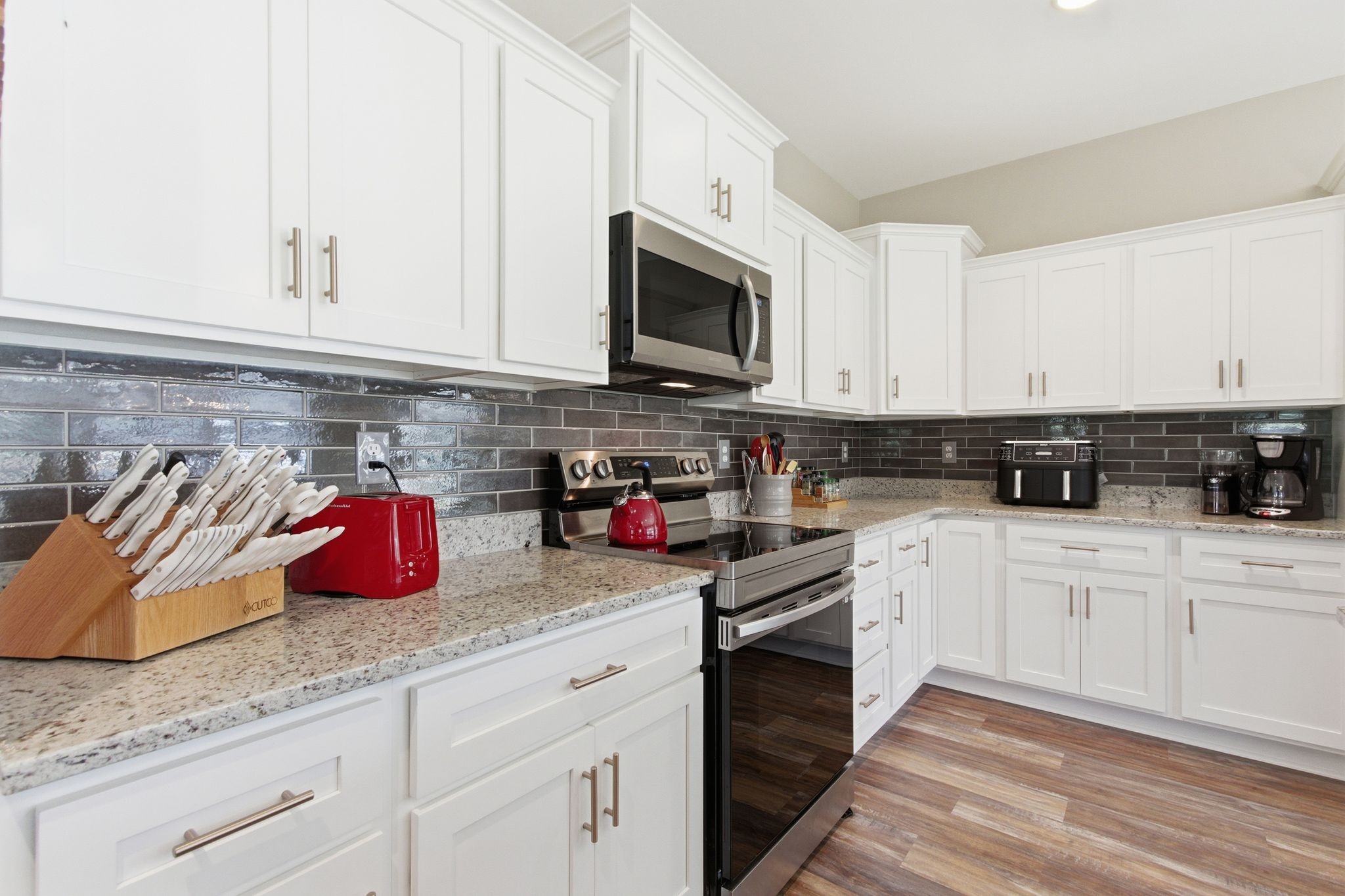 2705 Mc Connell Road Cornersville, TN 37047 - Photo 21 of 41 a kitchen with granite countertop white cabinets stainless steel appliances and sink