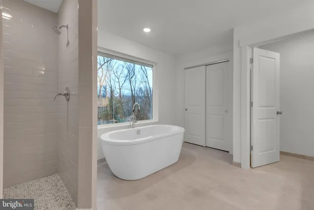 a white bath tub sitting in a bathroom near a window