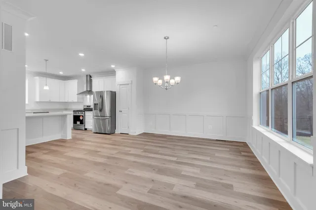 a view of kitchen with granite countertop cabinets and refrigerator