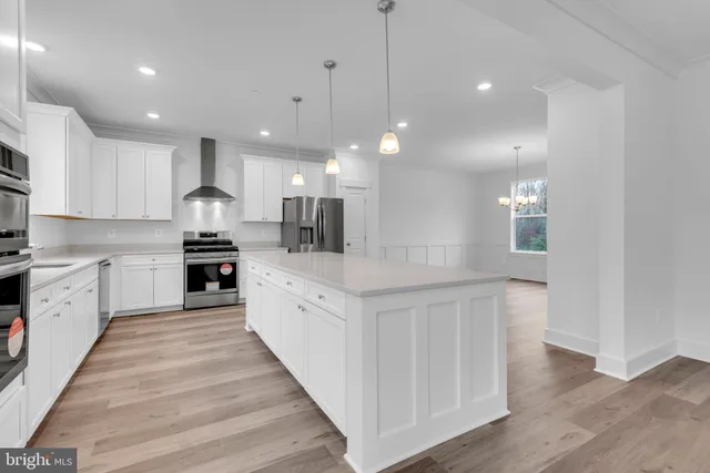 a large kitchen with stainless steel appliances kitchen island a large counter top and a wooden floors
